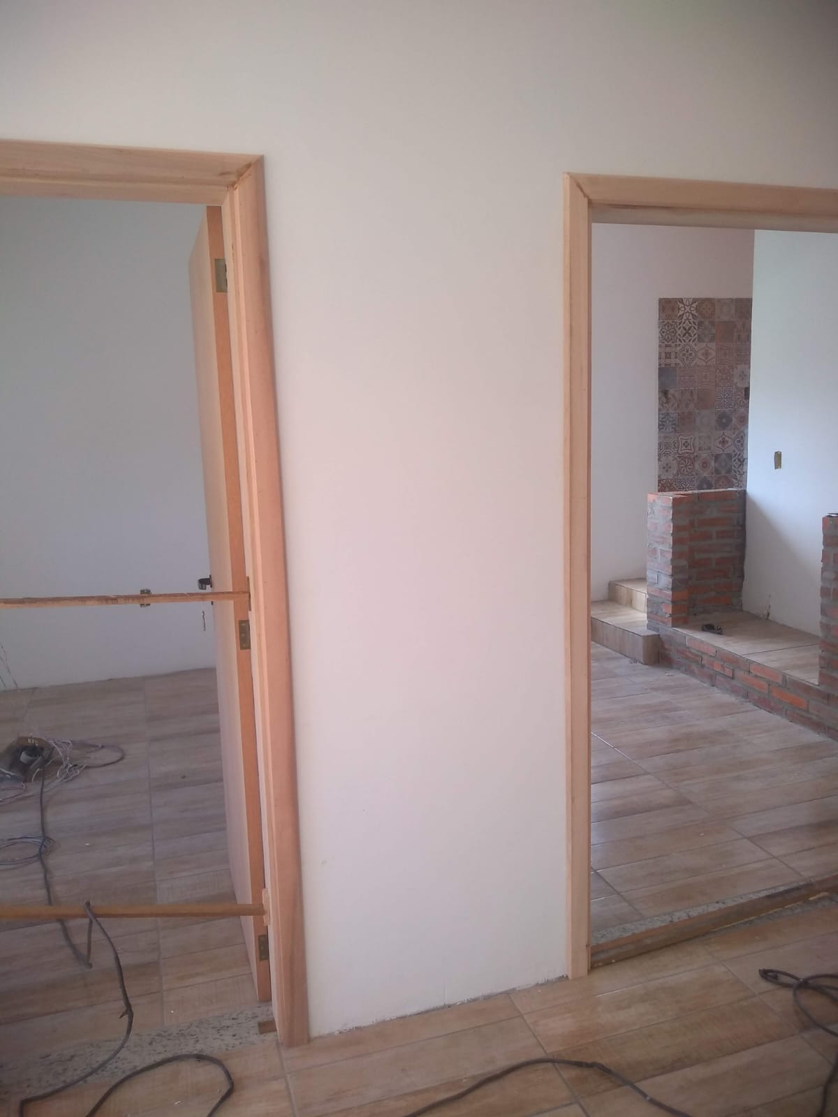 Obra mostrando colocação de pisos e portas de madeira